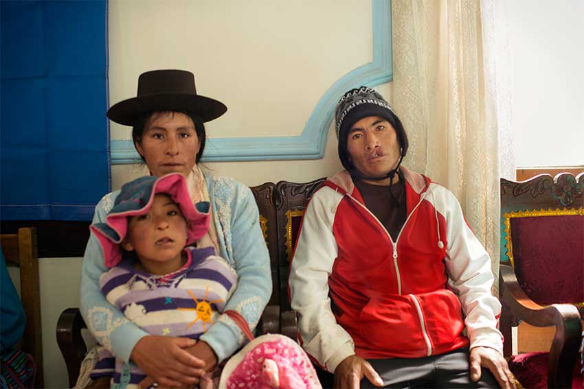 faustino before cleft surgery sitting with his wife and daughter
