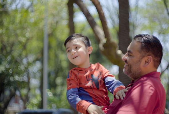 javier carga a su hijo damian y sonrie