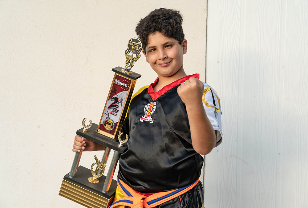 juan smiling and holding a trophy