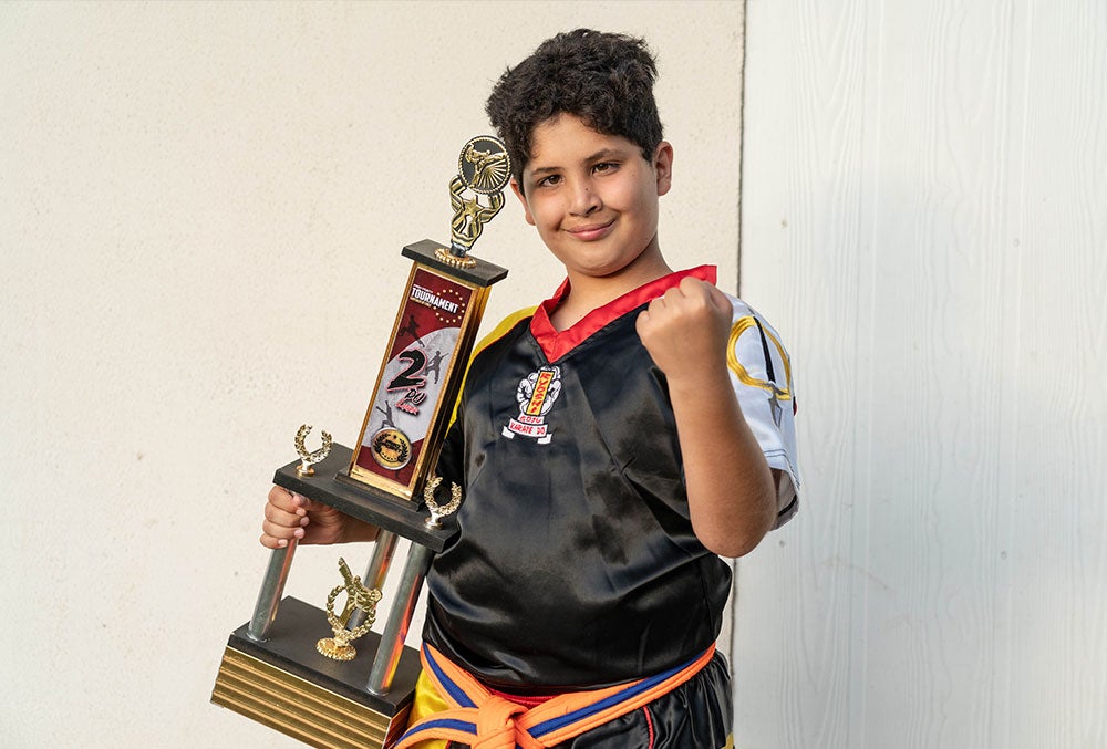 juan sonrie y sostiene un trofeo