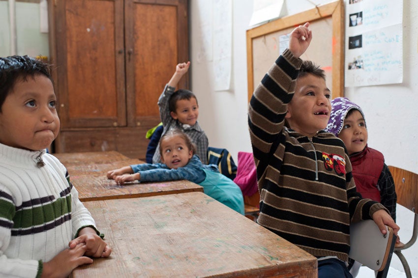 Students raising their hands in Maria's class