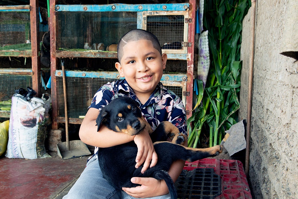 ramses smiling and holding a puppy