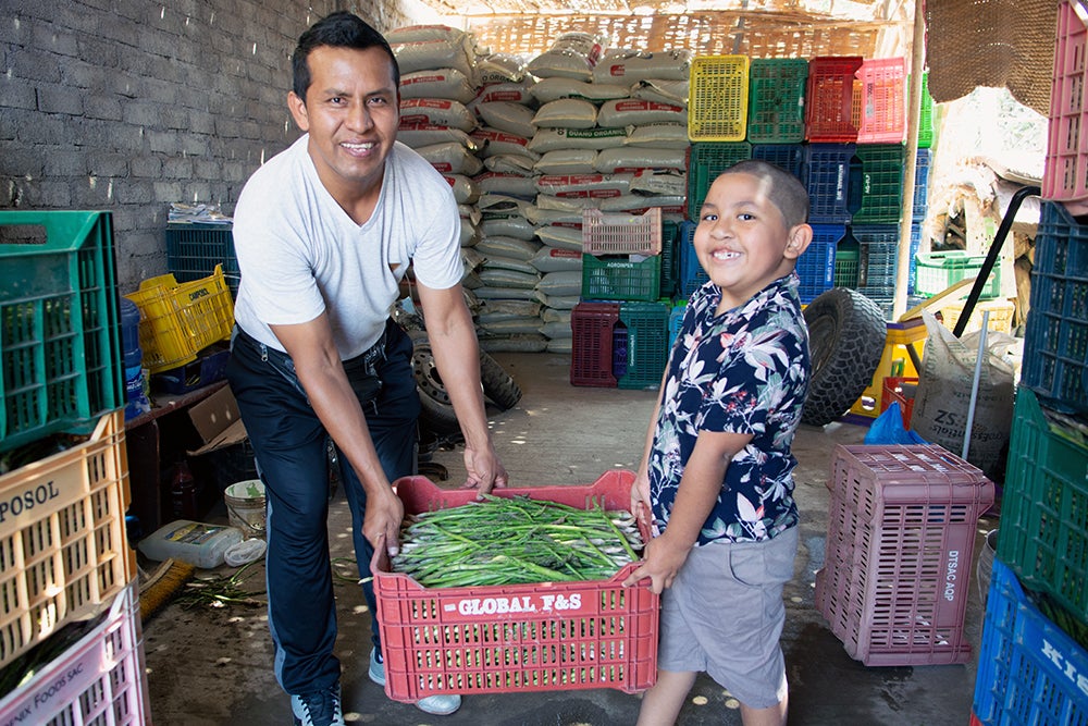 ramses y su padre luis sonrien y cargan una caja