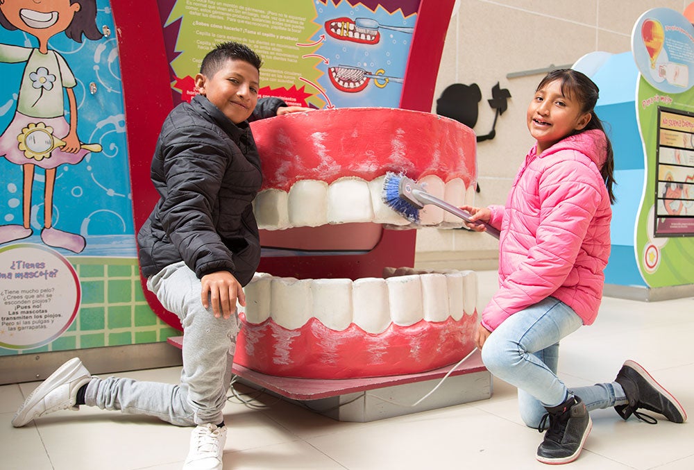 Alex y Kendra cepillan una dentadura gigante