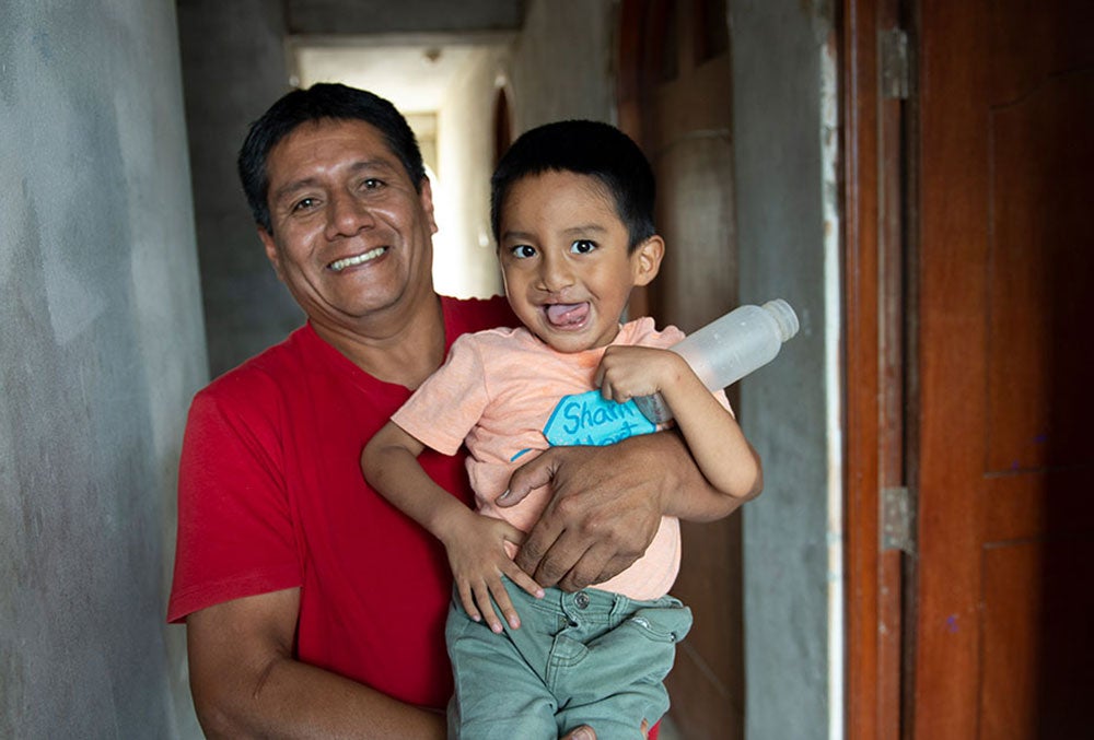 Anghelo sonriendo en brazos de su padre