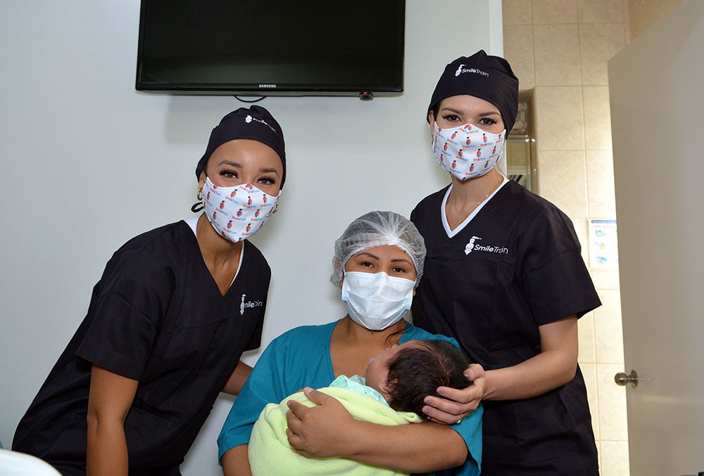 Elle Smith y Yely Rivera con una madre después de la cirugía de paladar hendido de su hijo