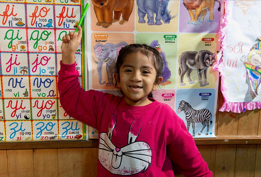 kristhell pointing to a board at her school