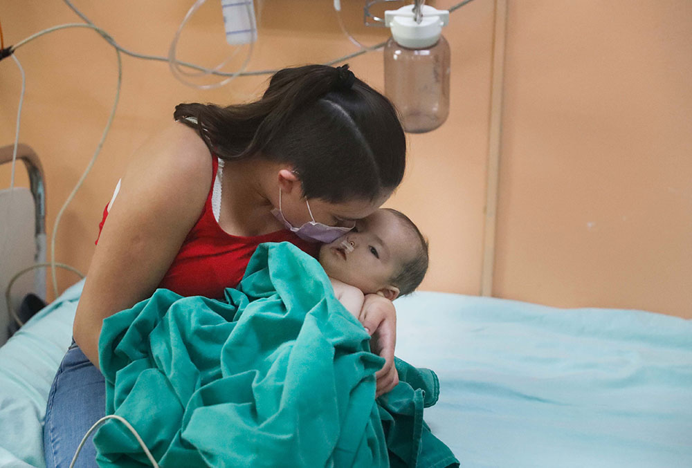 Rocio holding Maxi after his cleft surgery