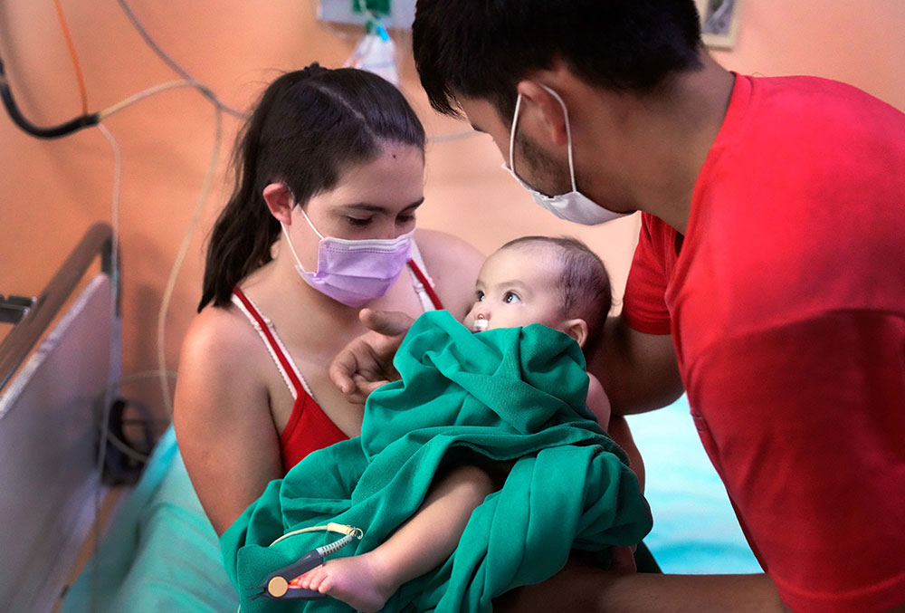 Rocio and Edgar holding Maxi after his cleft surgery