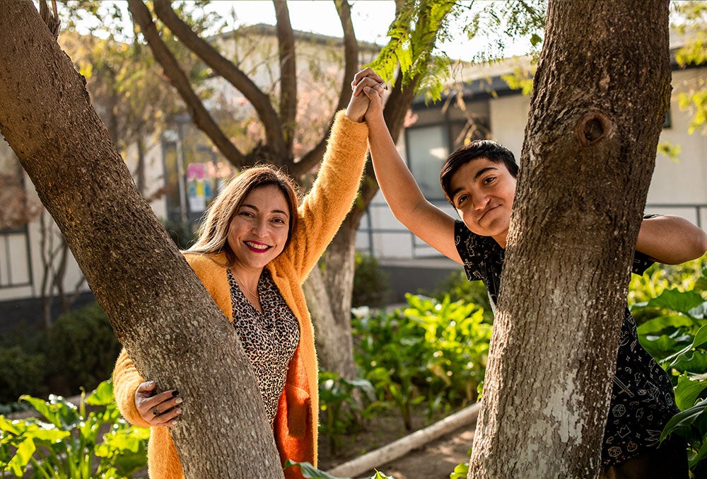 Vicente smiling and holding hands with his mother, Paola