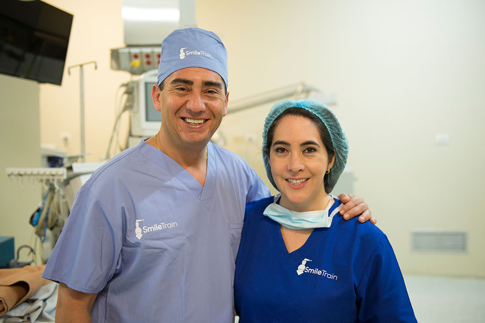 Dr. Andrea Astudillo and her brother Dr. Cristian Astudillo Carrera smiling in scrubs