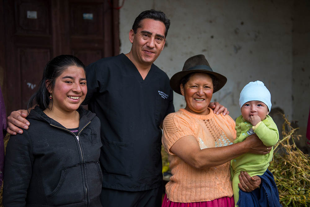 El Dr. Cristian Astudillo Carrera sonriendo con la familia de uno de sus pacientes