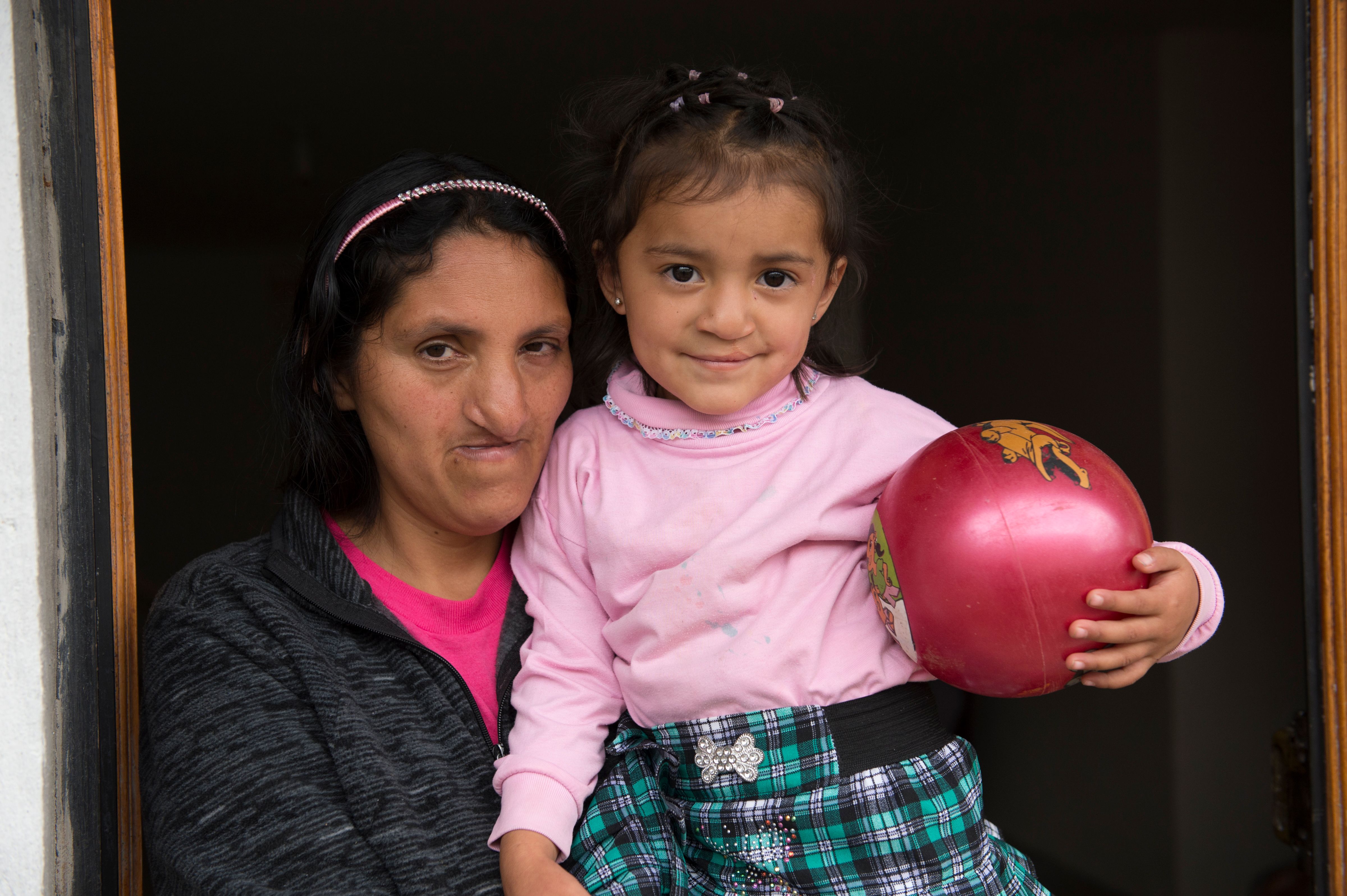 Estefania holding a ball and smiling with her mother Lourdes