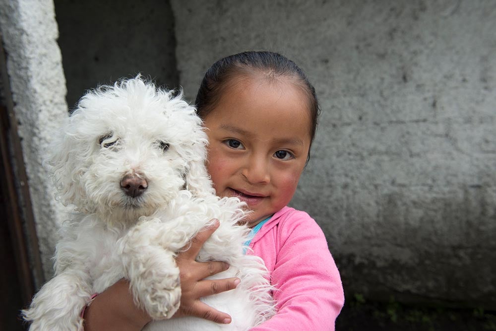 fernanda sonríe y sostiene un perro