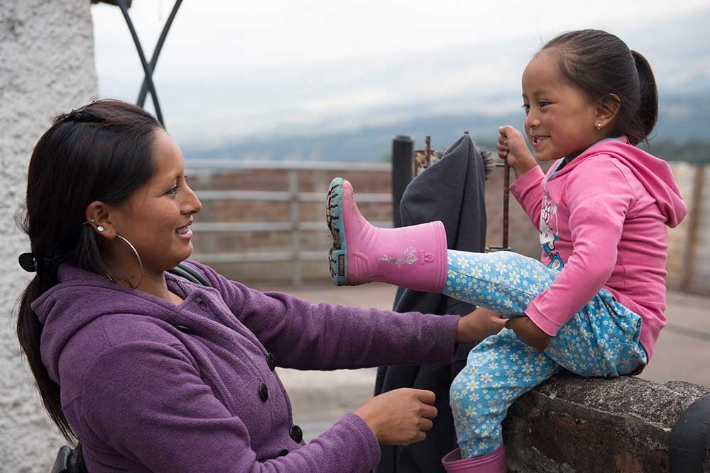 Fernanda smiling and putting on boots