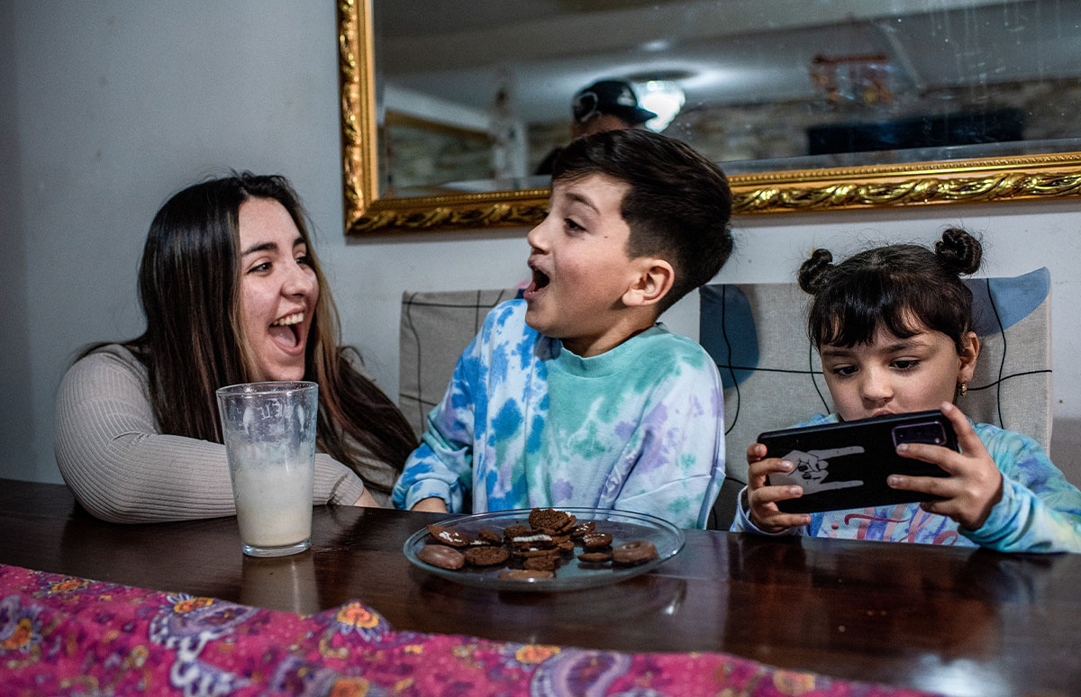 Joaquín ríe con su madre Javeria mientras su hermana Amanda juega con su teléfono