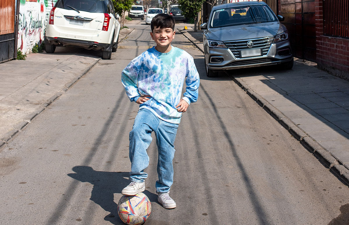 Joaquin posing with his foot on a football