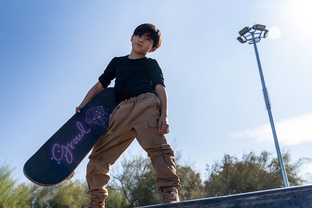 Tomas poses on a halfpipe with his skateboard