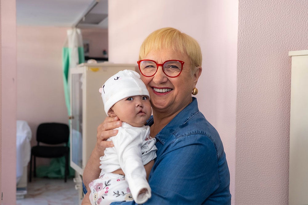 Lidia holding a baby just before the surgery that will change her life