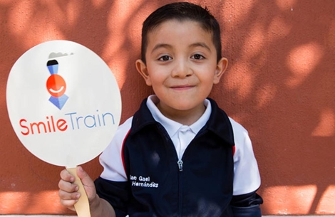 Gael holding a Smile Train sign