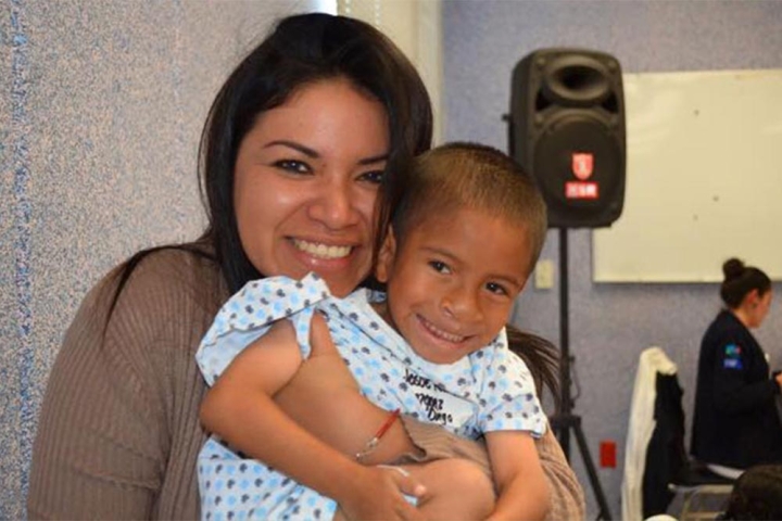 Karla sostiene a un paciente y sonrie