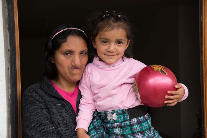 Estefania sosteniendo una pelota y sonriendo con su madre, Lourdes