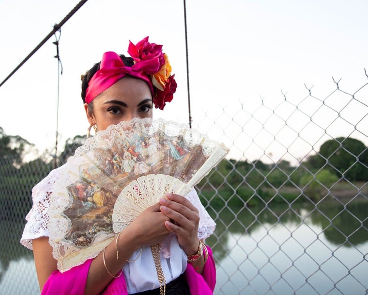 Adahara putting a traditional Mexican fan over her mouth