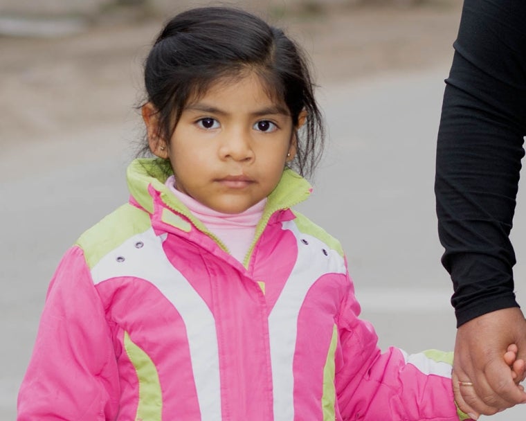 Mia holds Luz's hand